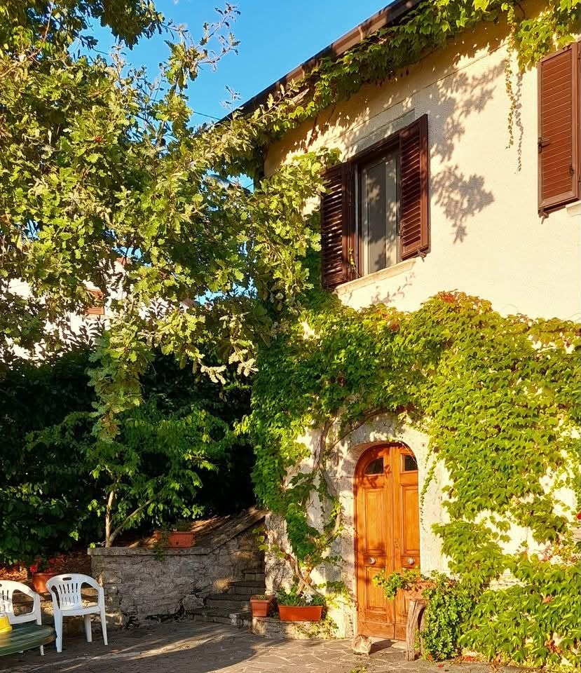 Facciata di Casale Santilli avvolta dal verde